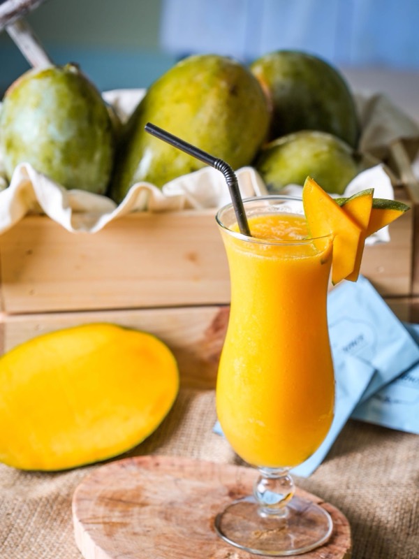 A glass of mango juice with mango slices