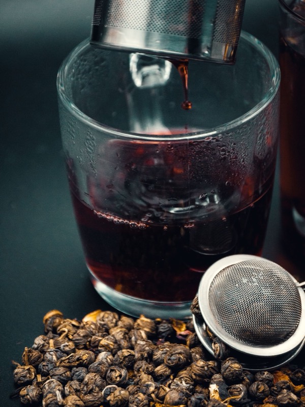 Tea being filtered into a glass